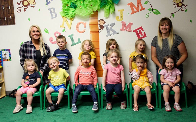 Kids in classroom in two rows with teachers on sides